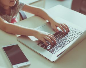 Cute little girl using laptop at home