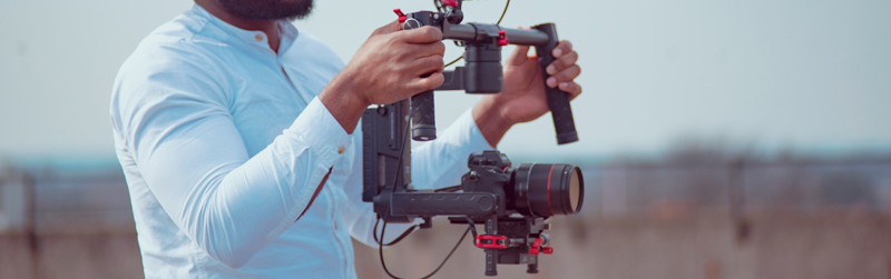 man filming outside holding camera